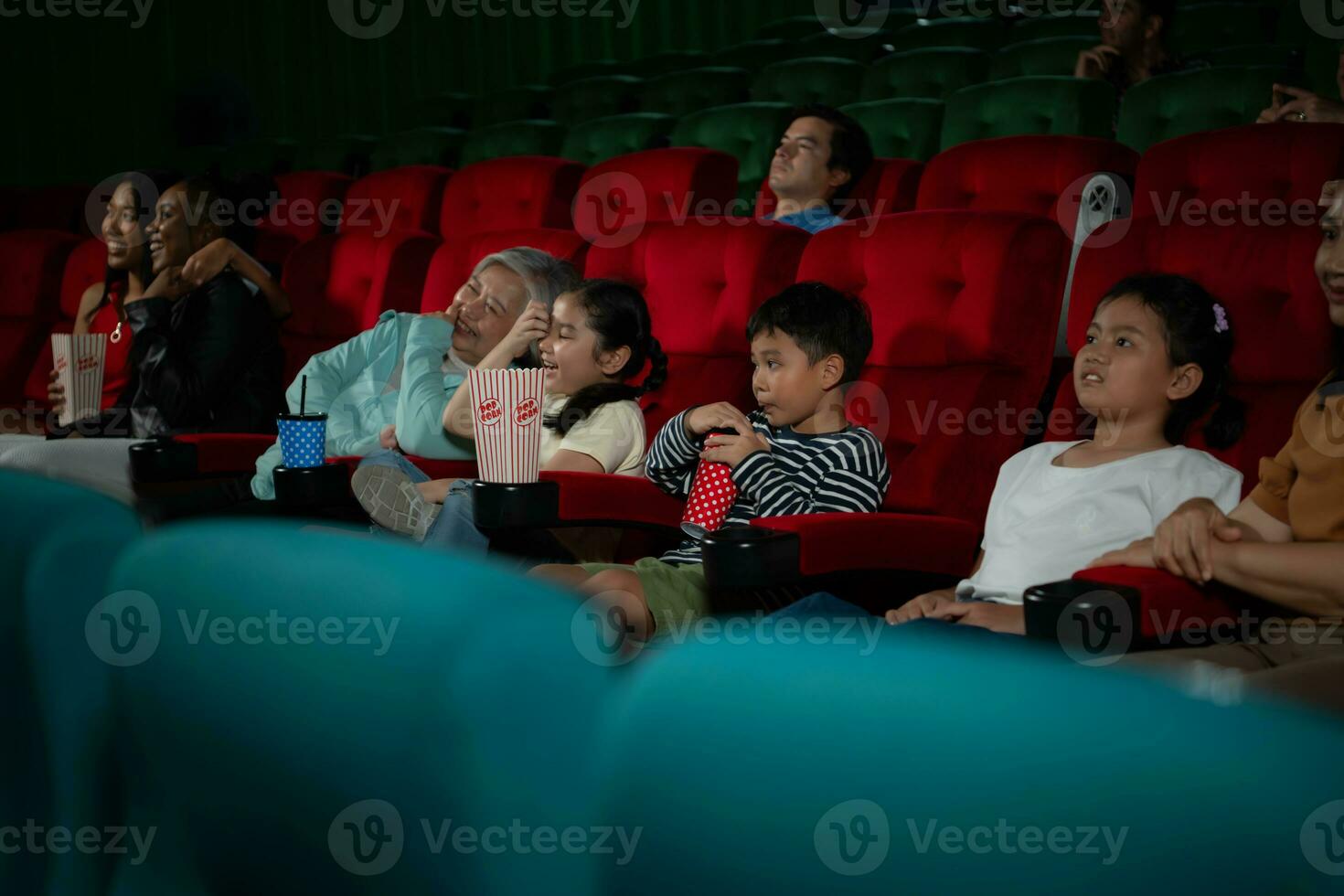 Aziatisch moeder en dochter aan het kijken film in bioscoop. familie tijd concept. foto