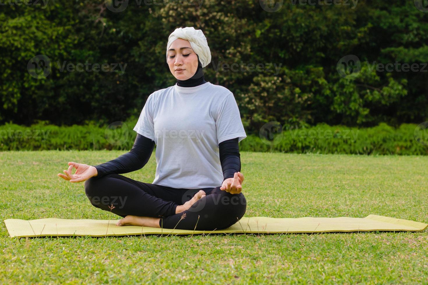 aantrekkelijke vrouw in hijab training in park, mediteren. foto