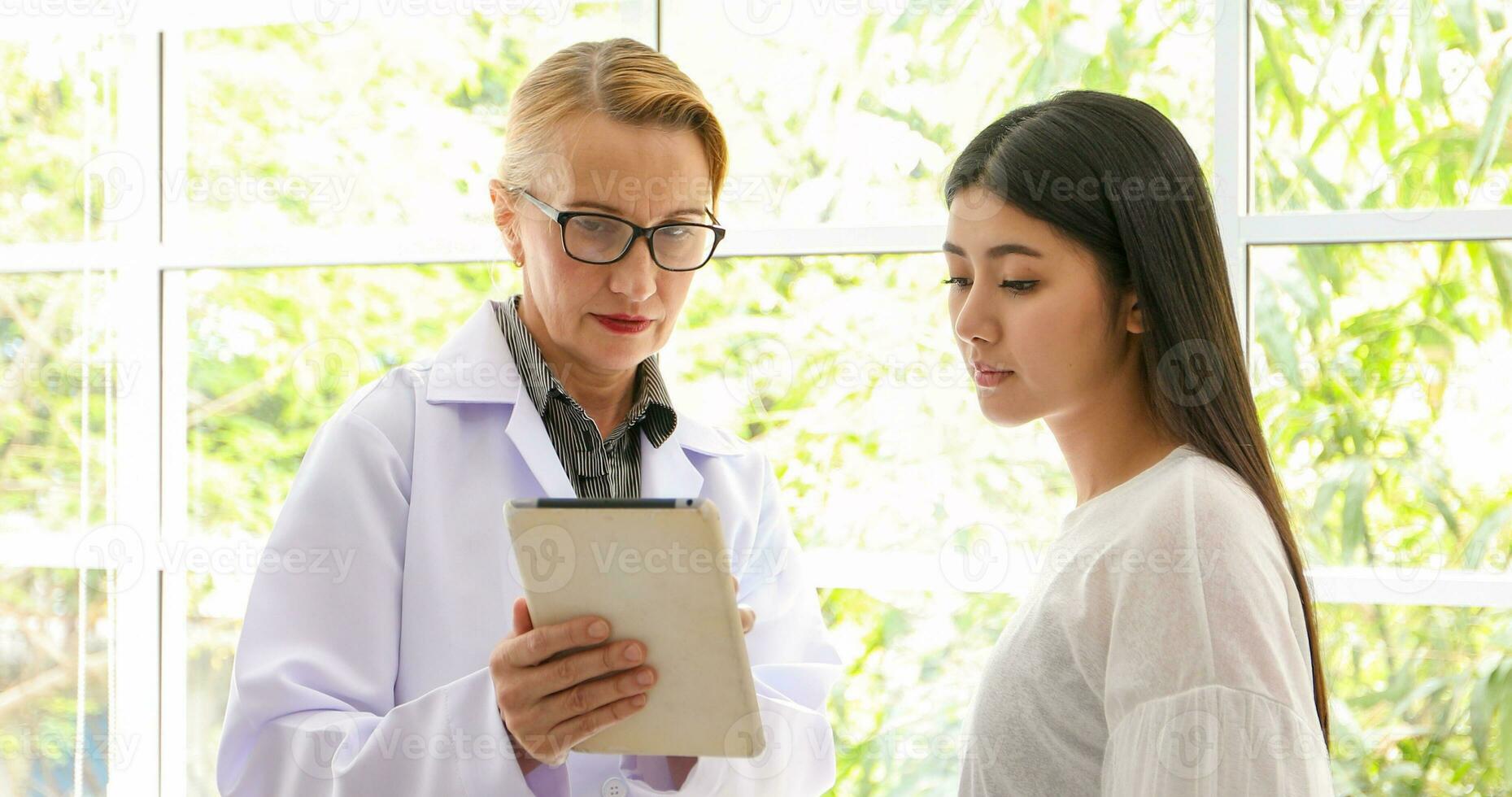 Aziatisch vrouw geduldig zittend met dokter over haar ziekte en tonen röntgenstraal resultaten foto