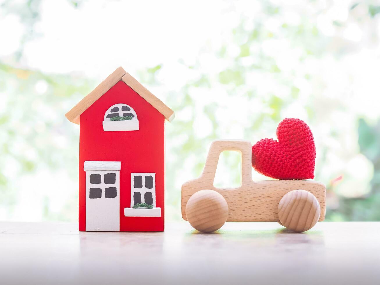 miniatuur huis en houten speelgoed- auto. concept van besparing geld voor kopen een huis en auto. foto