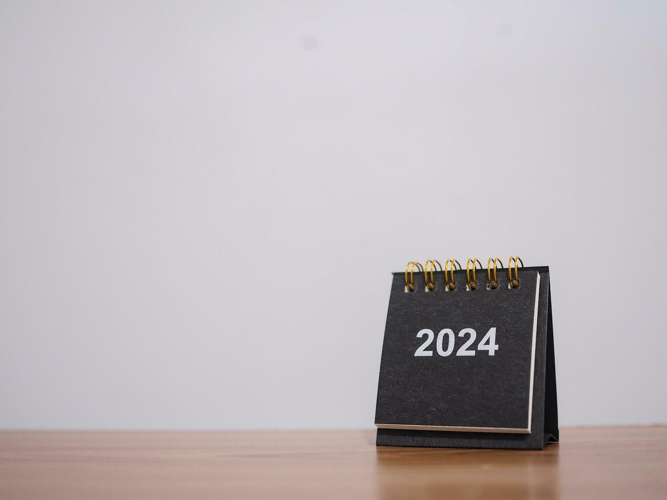 dichtbij omhoog 2024 bureau kalender Aan de tafel met kopiëren ruimte. oplossing, doel, actie, planning, en beheren naar succes bedrijf. foto
