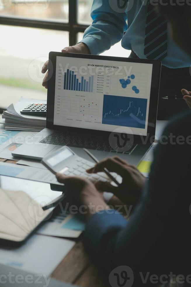 financiële analisten analyseren zakelijke financiële rapporten over een investeringsproject voor digitale tabletplanning tijdens een discussie op een bijeenkomst van bedrijven die de resultaten van hun succesvolle teamwerk laten zien. foto