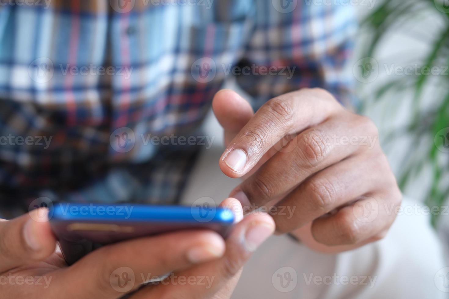 close-up van de hand van de jonge man met behulp van slimme telefoon. foto