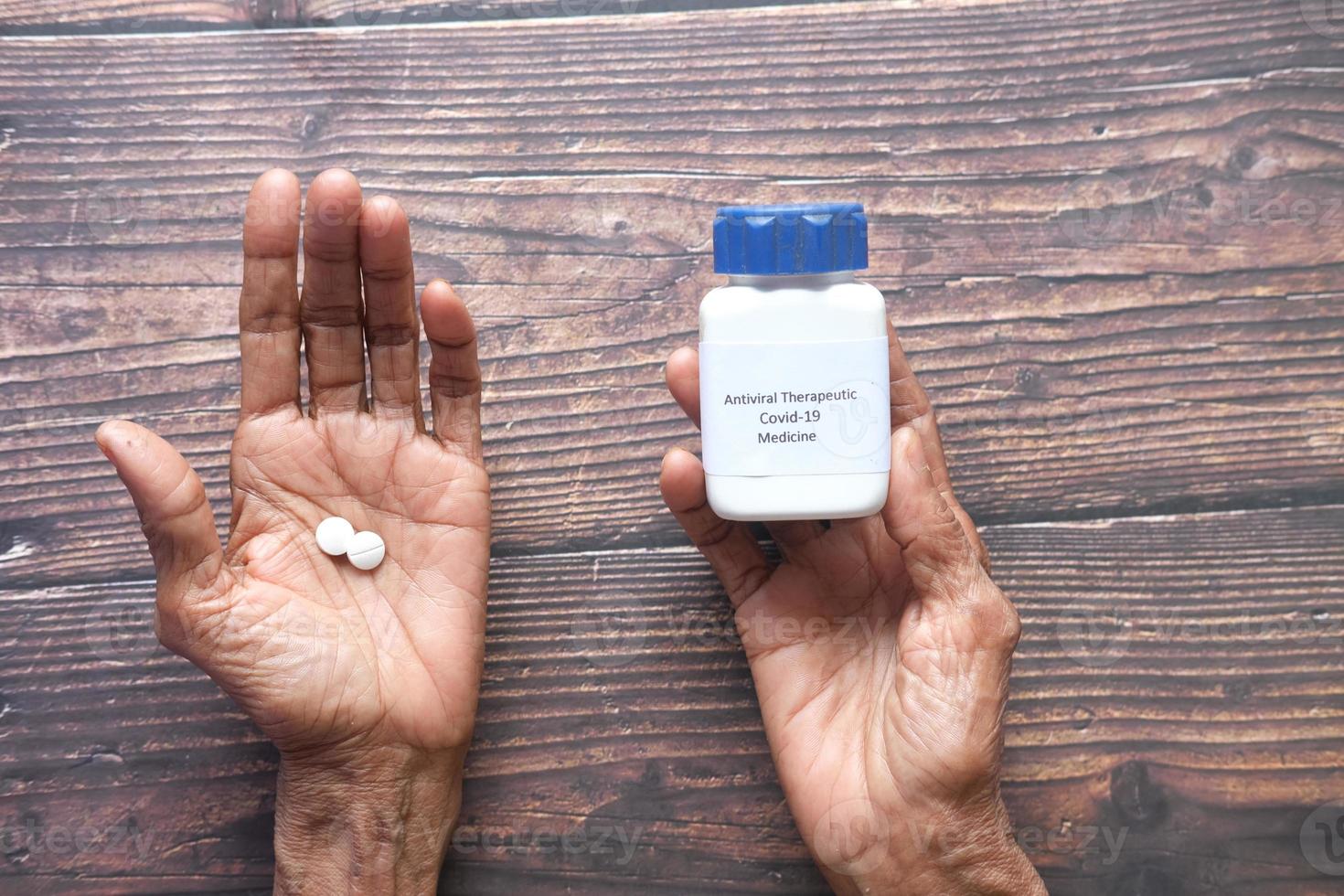 senior vrouwen houden covid 19 medische mediale pillen op tafel vast foto