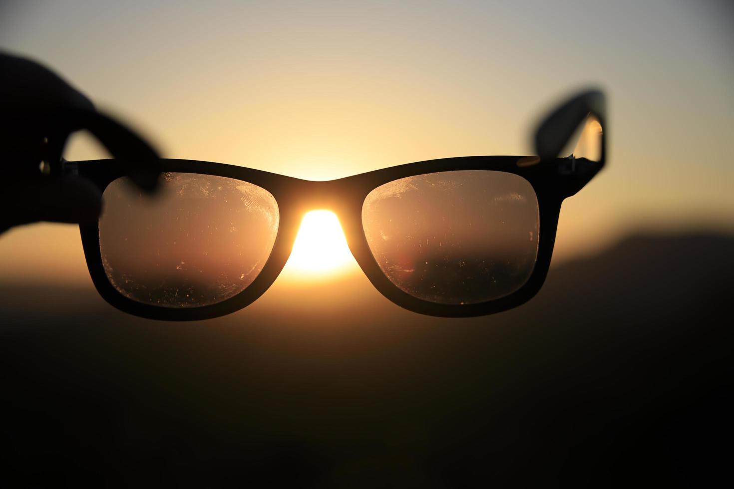 kleurrijke zonsondergang door een zonnebril foto