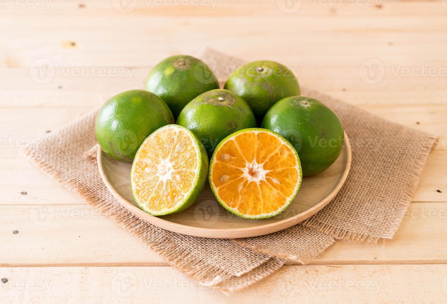 verse sinaasappel op houten plaat op tafel foto