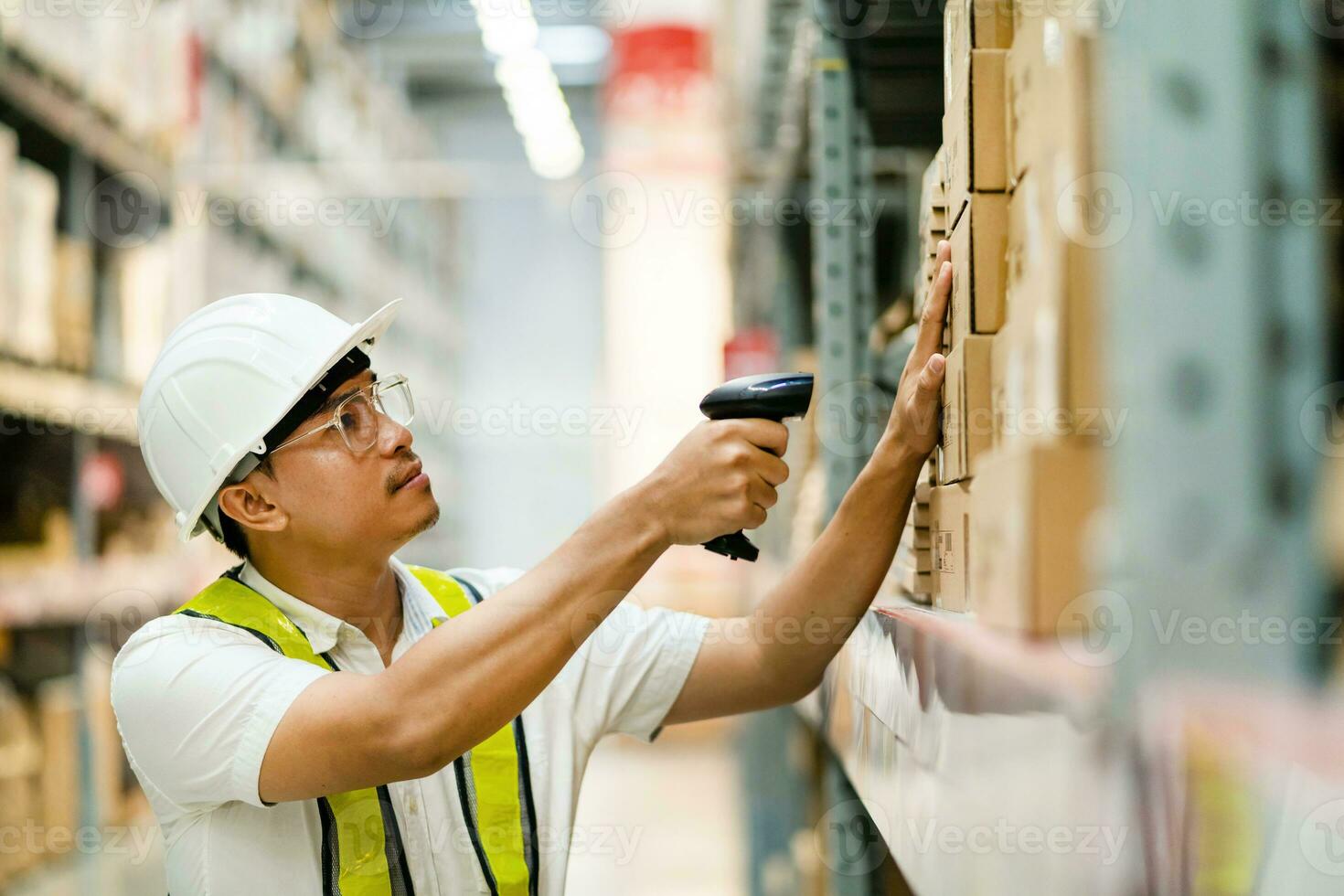 mannetje magazijn arbeider scannen barcodes Aan dozen in een magazijn. mannetje magazijn arbeider werken met streepjescode scanner. foto