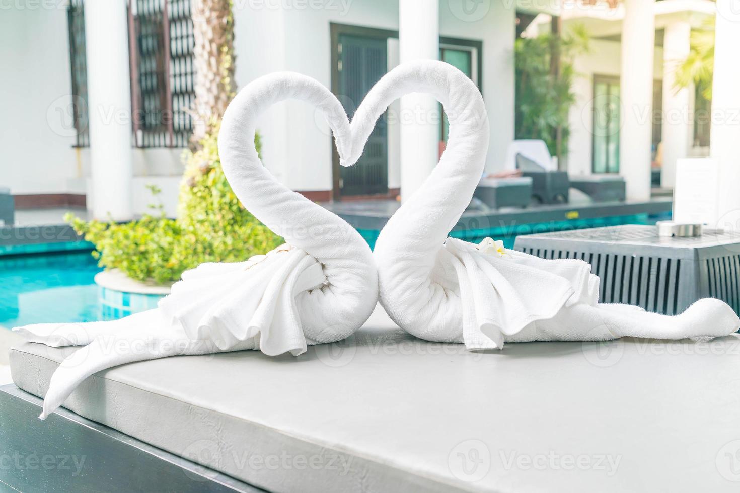 close-up van twee mooie handdoeken zwanen op bed zwembad - met sunflare-effect foto