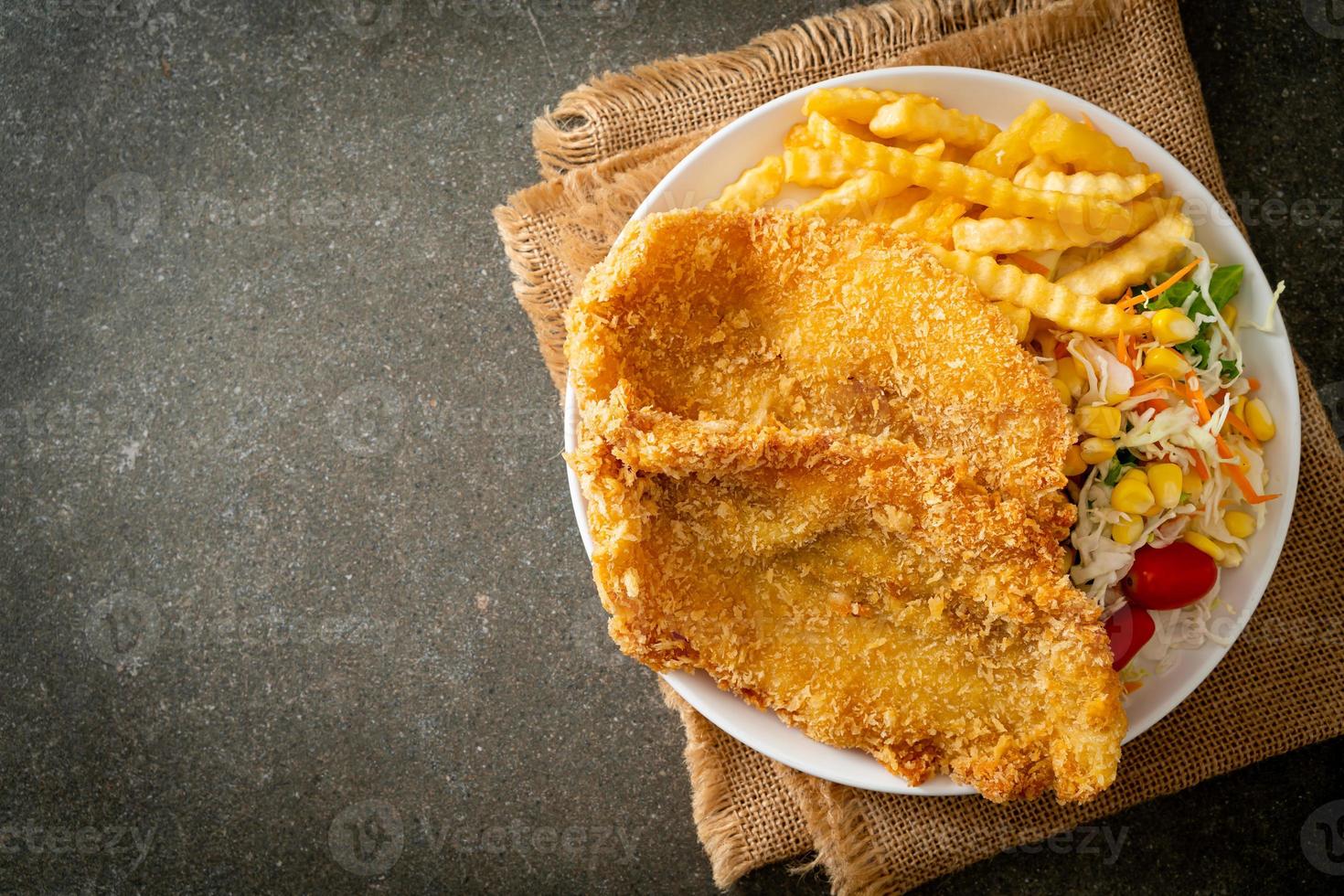 fish and chips met minisalade op wit bord foto