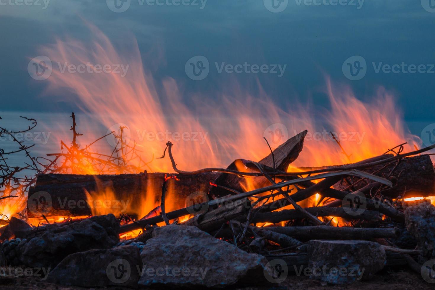 kampvuur bij schemering op strand foto