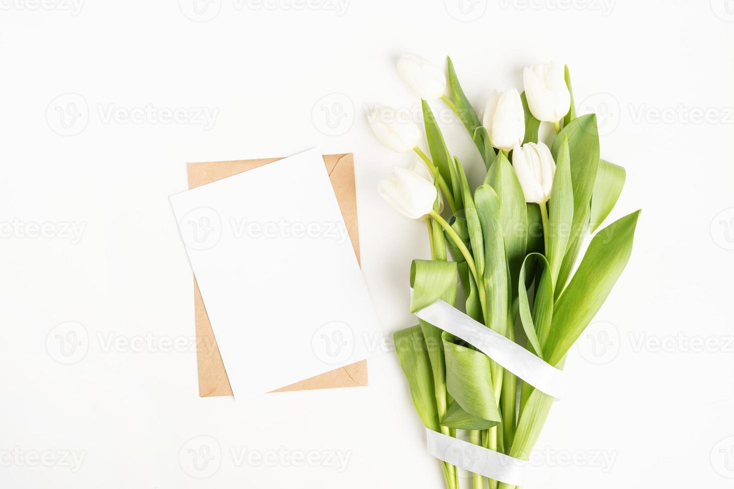 tulpenbloemen en blanco kaart met envelop bovenaanzicht foto