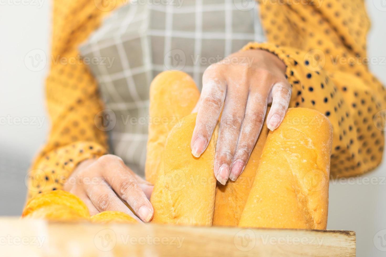 hand met emmerbrood vers in broodwinkel foto