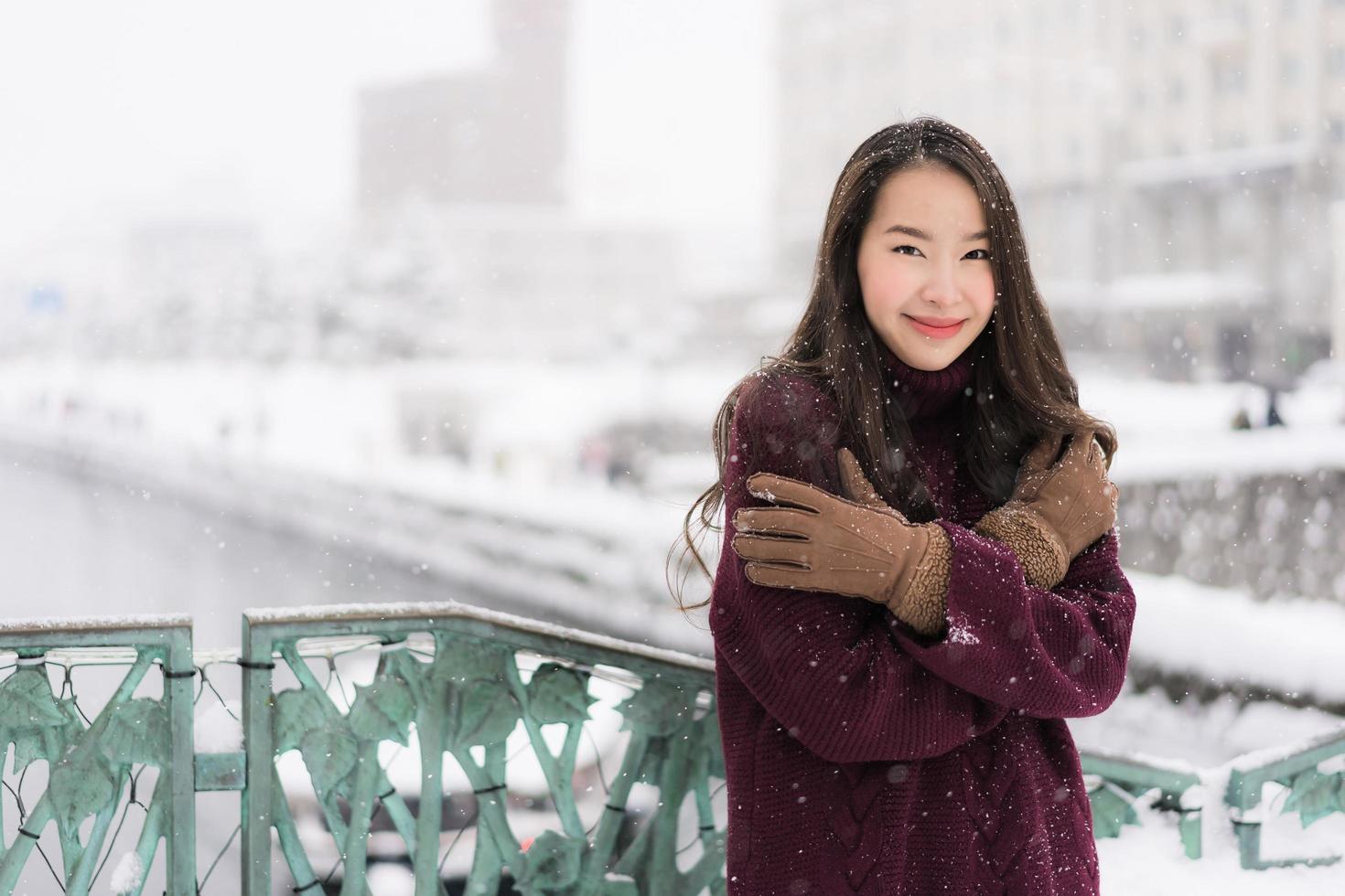 Aziatische vrouw die lacht gelukkig voor reizen in de sneeuw winterseizoen foto