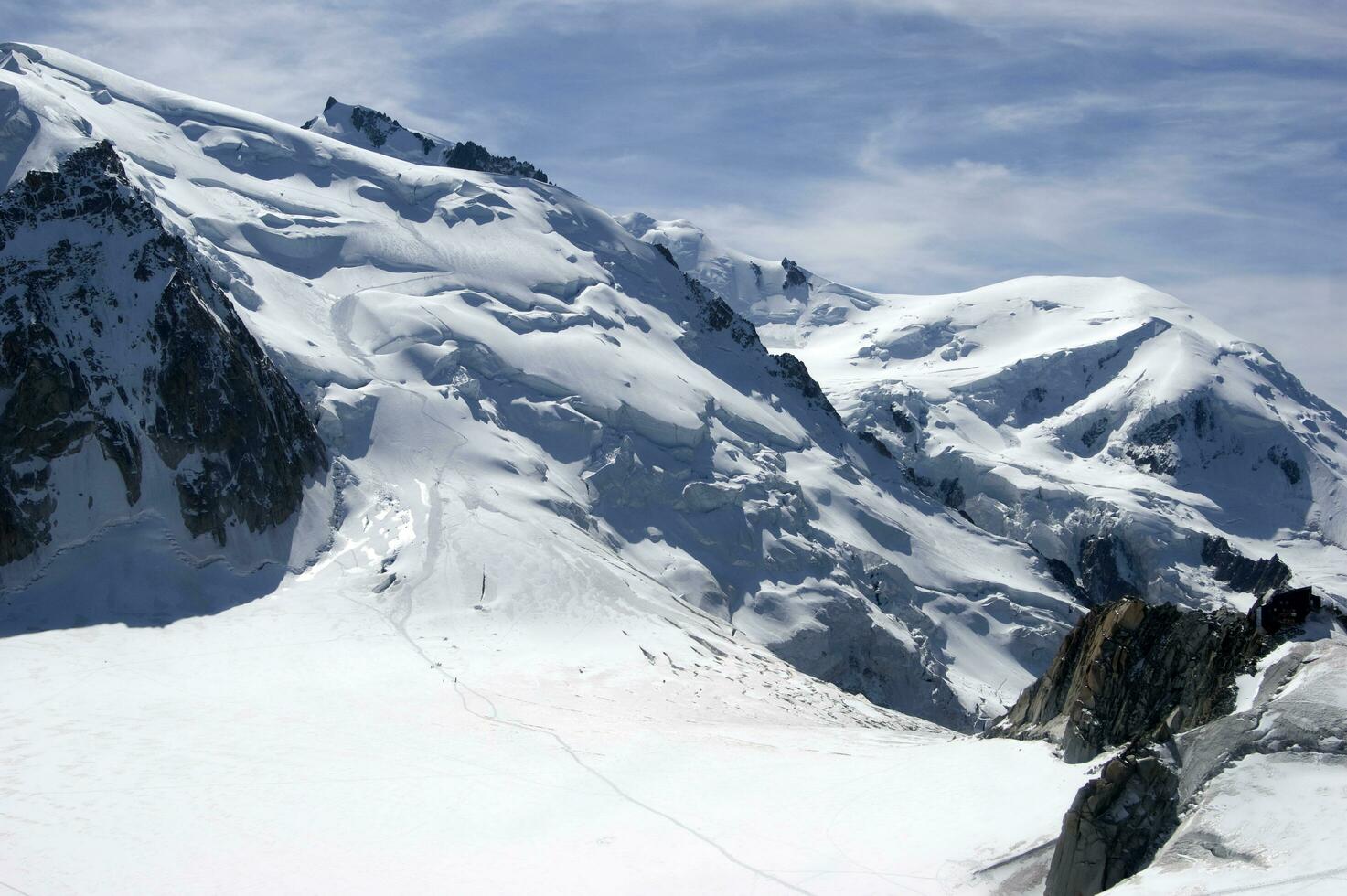 twee mensen zijn wandelen omhoog een berg met sneeuw gedekt bergen foto