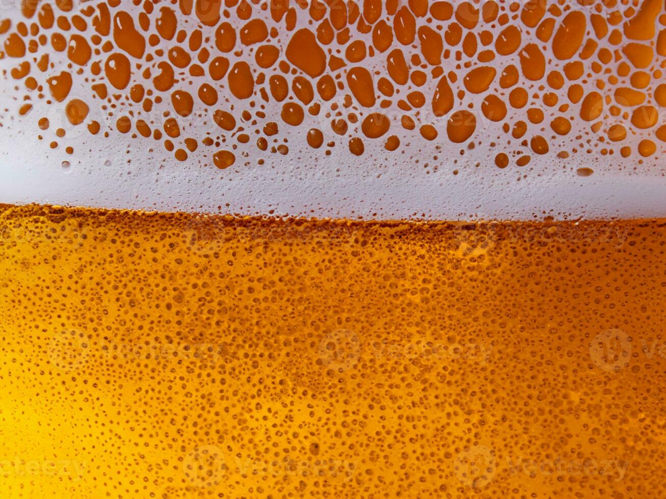 een bier in de glas met een schuim foto