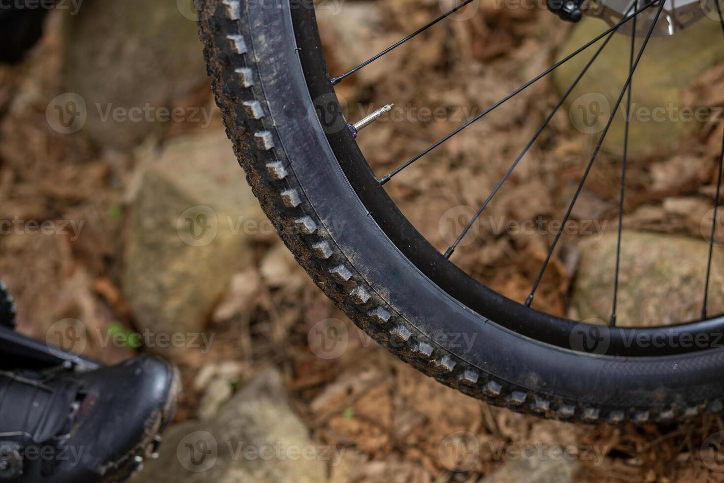 detail van een berg fiets band met een een beetje modderig zijwand staand Aan een rotsachtig oppervlak. foto