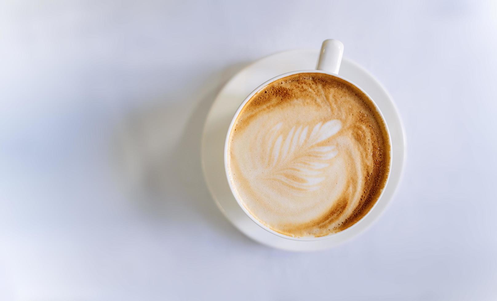 bovenaanzicht op een kopje koffie op een witte tafel foto