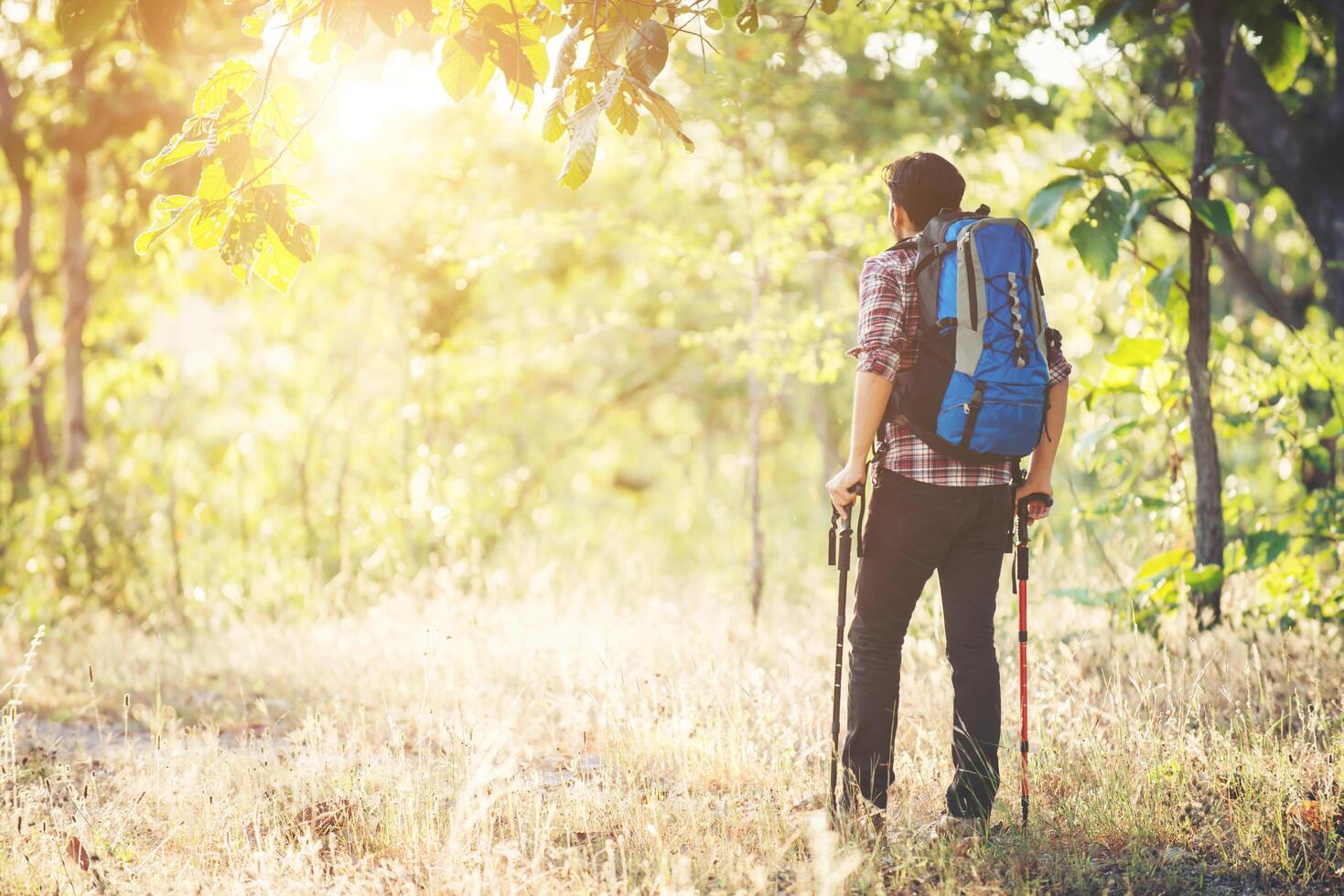 jonge hipster man lopen op de landelijke weg tijdens wandelingen op vakantie. foto