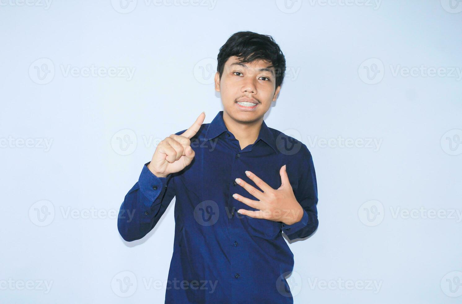 dankbaar Aziatisch zakenman is glimlachen na lijden van hart aanval tonen presenteren gebaar met richten vinger omhoog foto