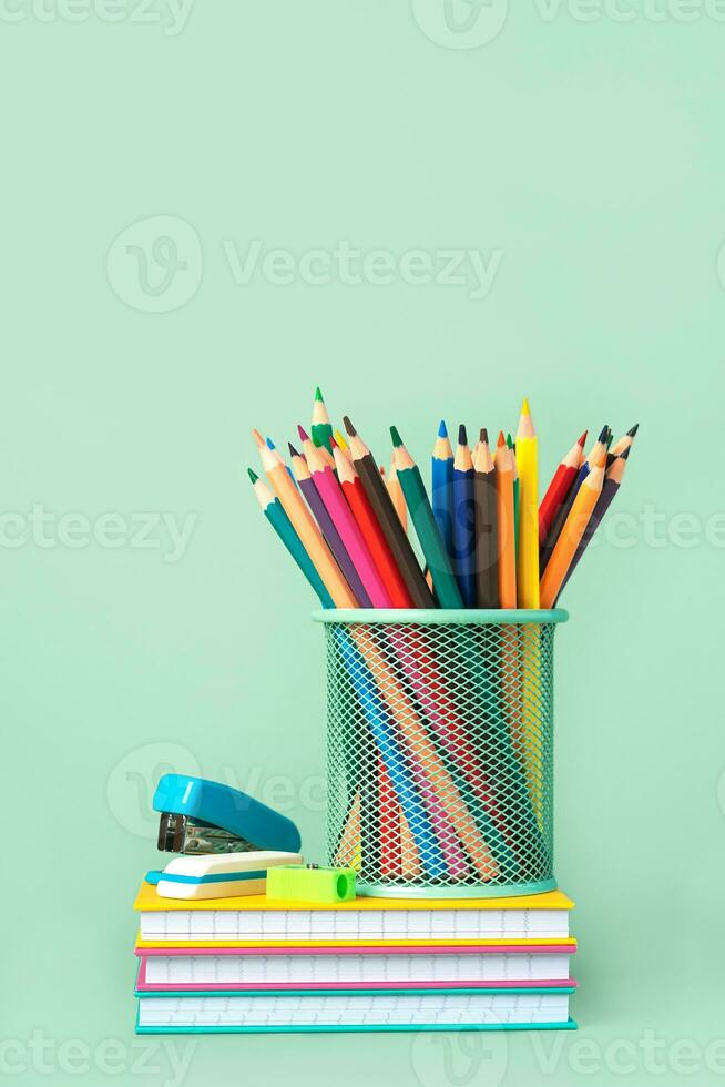 gekleurde potloden in pot met notebooks en school- benodigdheden. terug naar school- concept foto