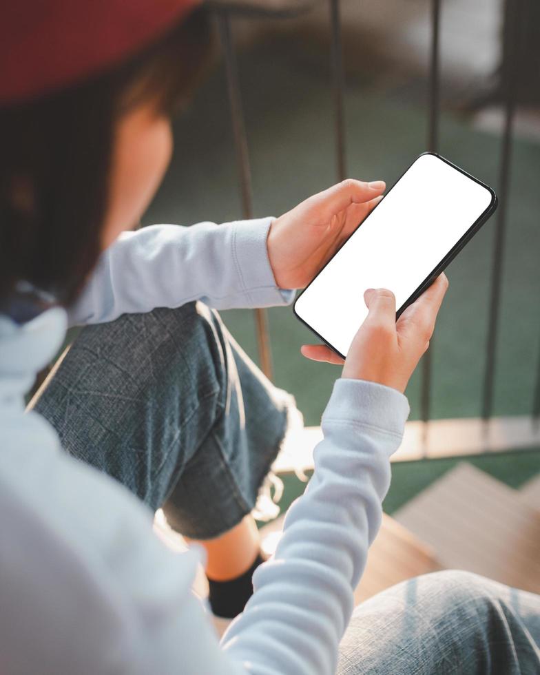 jonge vrouw die smartphone gebruikt met een leeg schermmodel foto