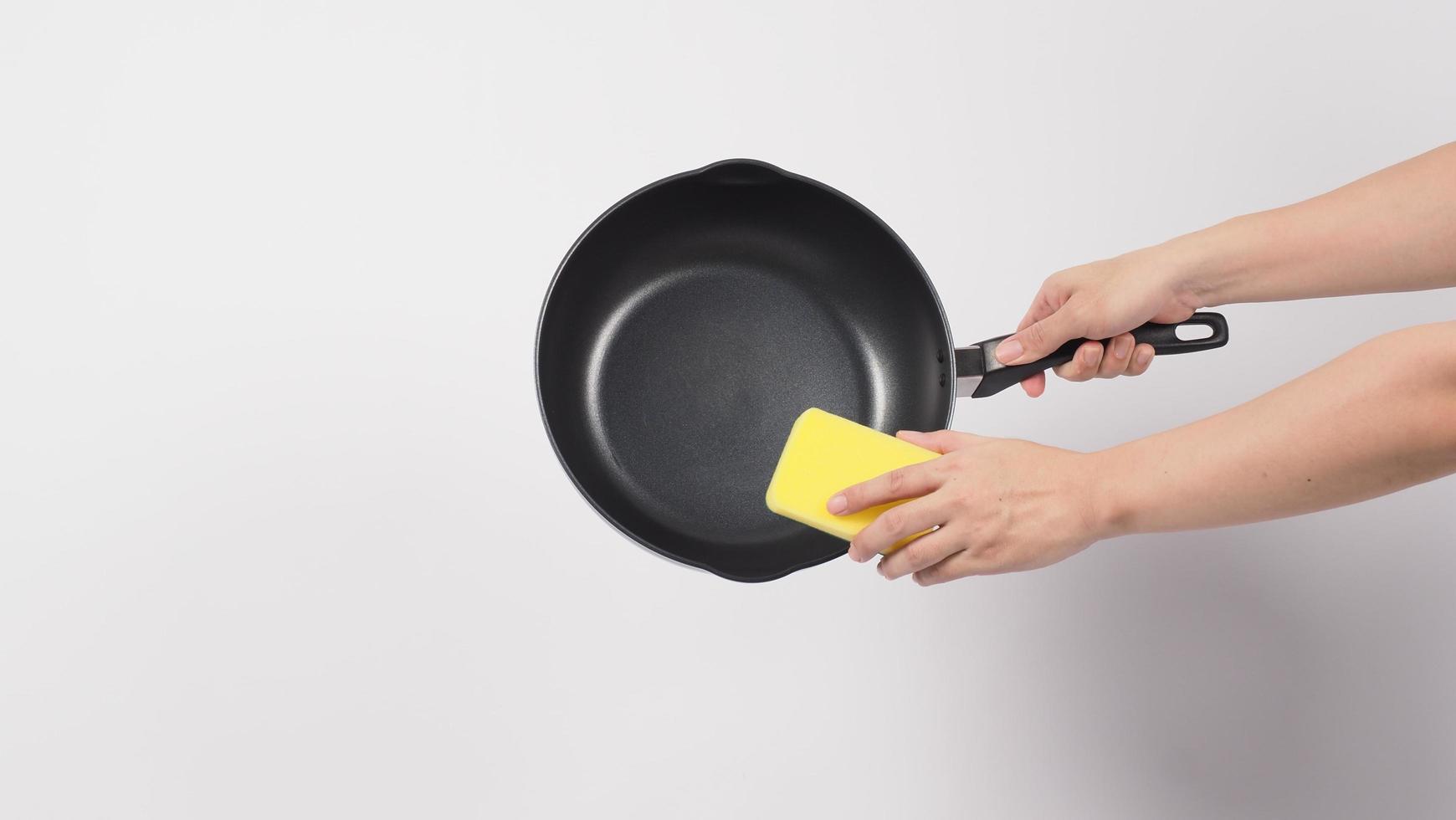 man hand op witte achtergrond schoonmaken van de anti-aanbak pan foto