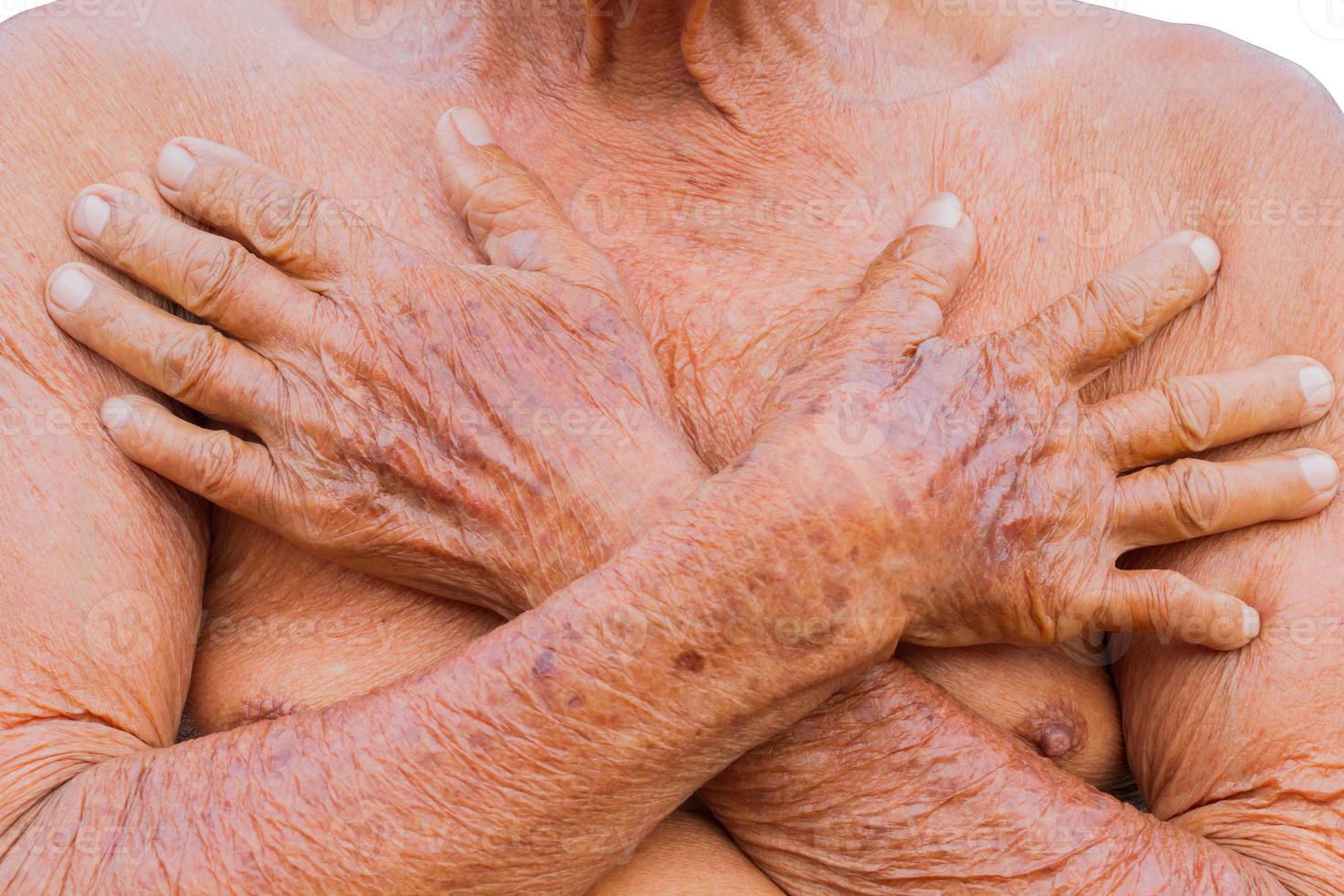 close-up aziatische senior man borst met textuur van twee bruine rimpel handen foto