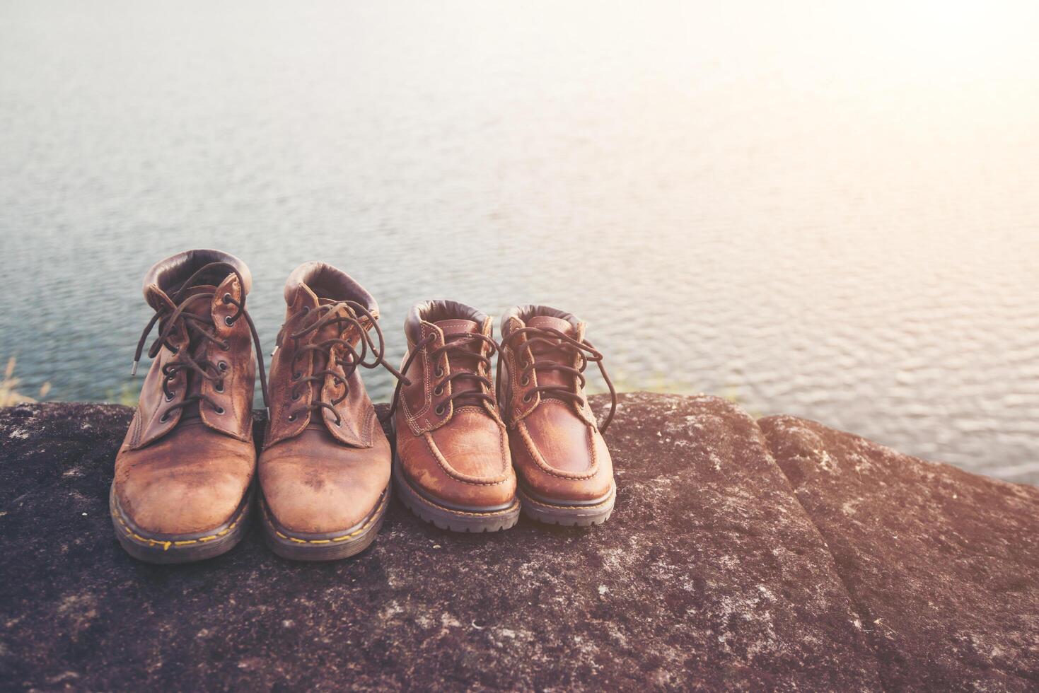 paar wandelschoenen op rots met de achtergrond van het natuurmeer. foto