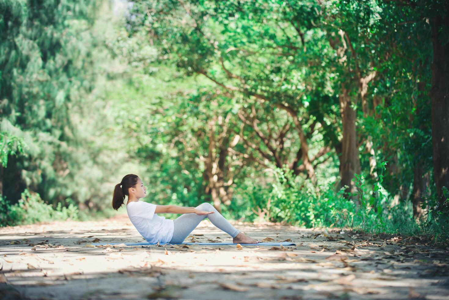 jonge aziatische vrouw die 's ochtends yoga doet in het park. gezond foto