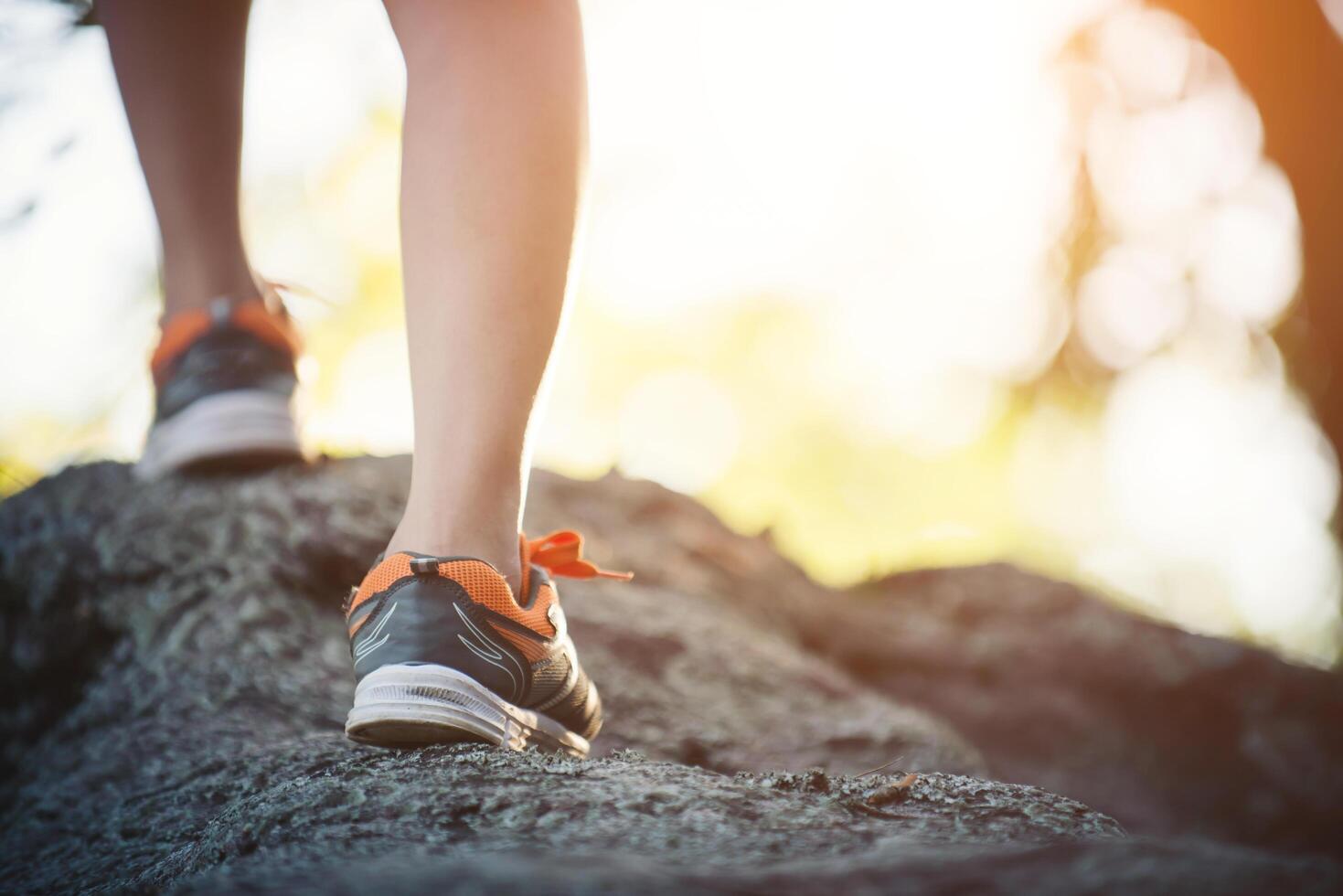 jonge runner vrouw benen close-up tijdens het rennen over de rots. foto