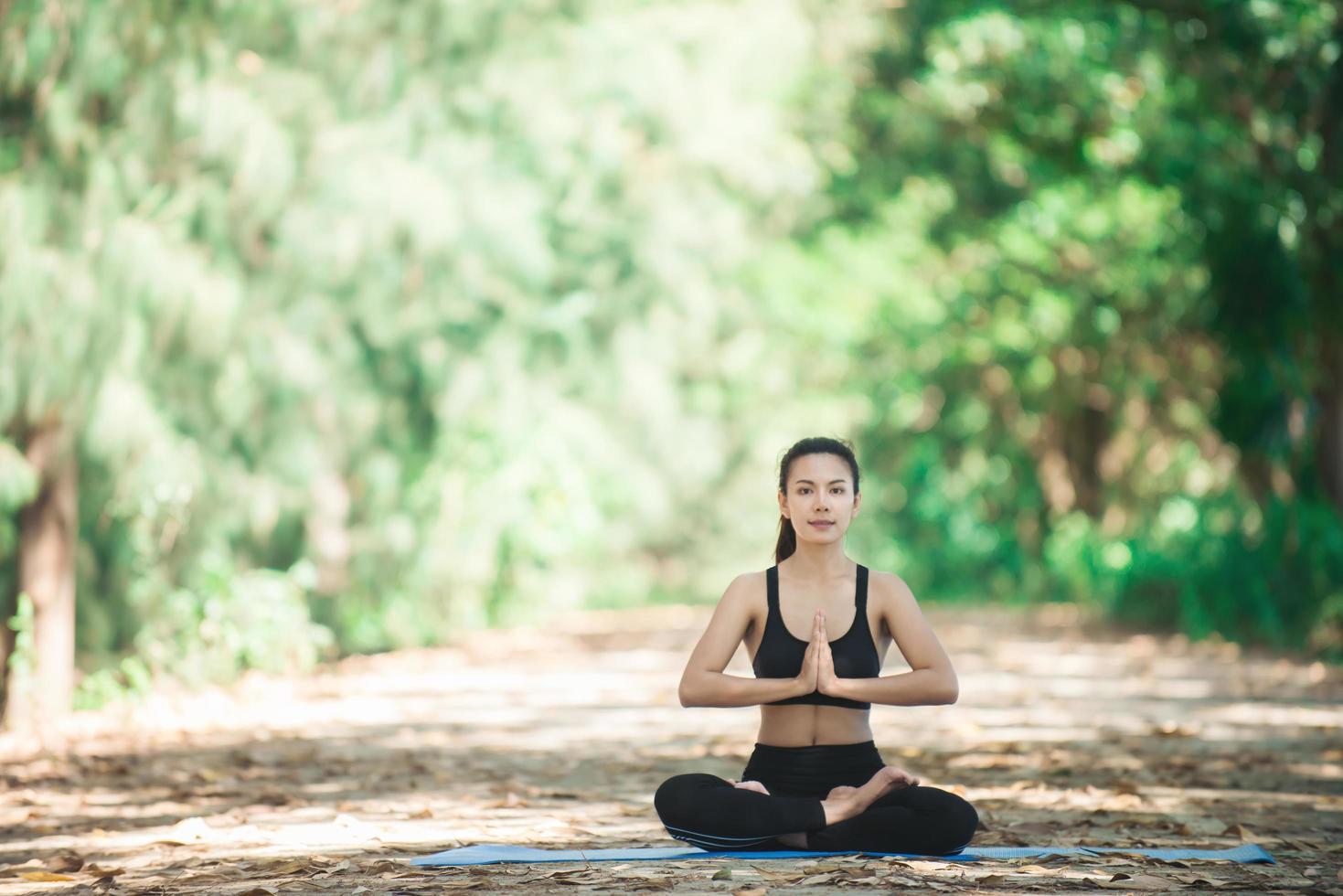 jonge aziatische vrouw die 's ochtends yoga doet in het park. gezond foto