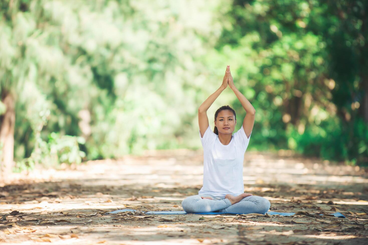 jonge aziatische vrouw die 's ochtends yoga doet in het park. gezond foto