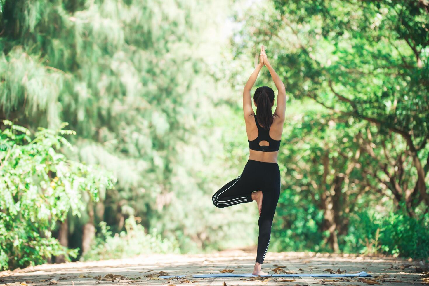 jonge aziatische vrouw die 's ochtends yoga doet in het park. gezond foto