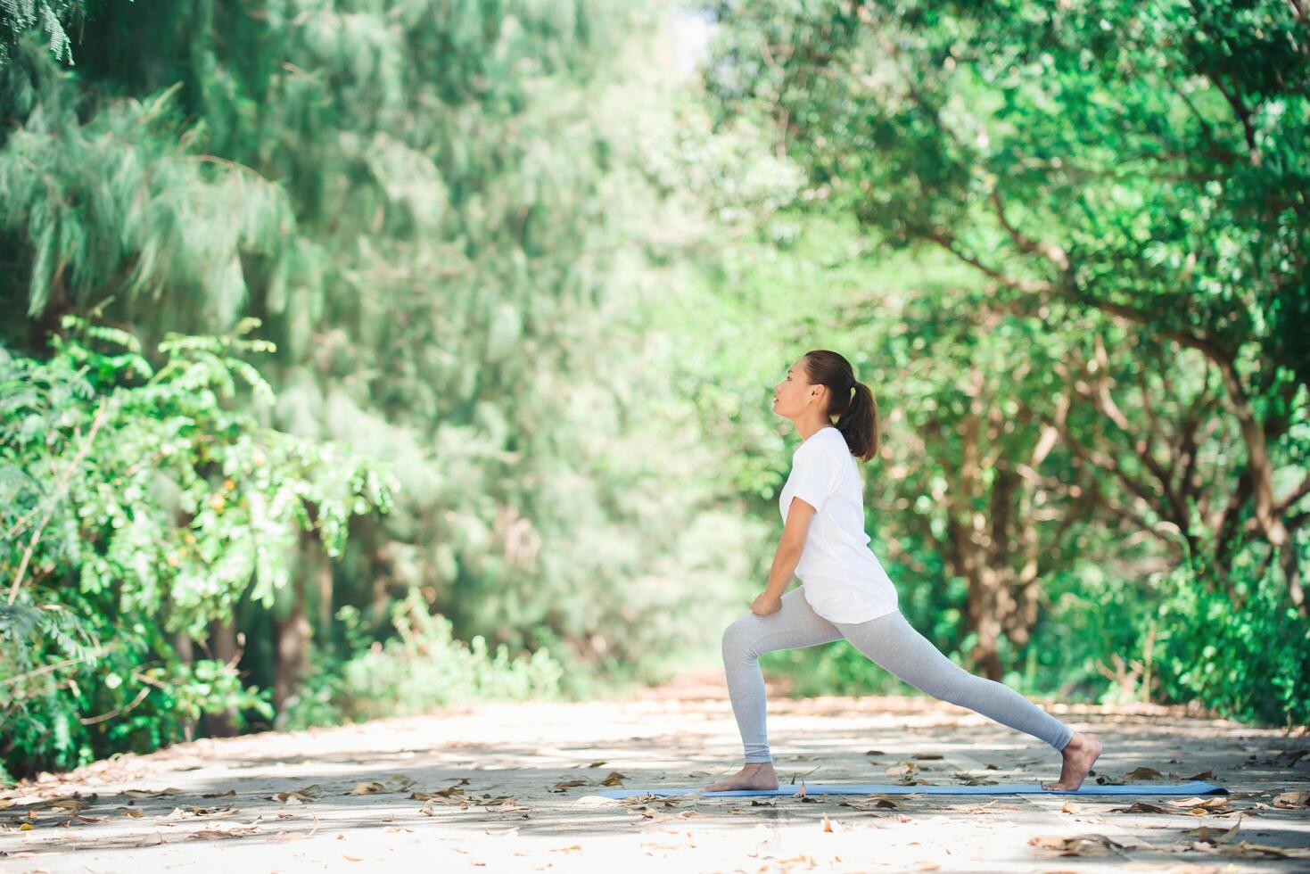 jonge aziatische vrouw die 's ochtends yoga doet in het park. gezond foto