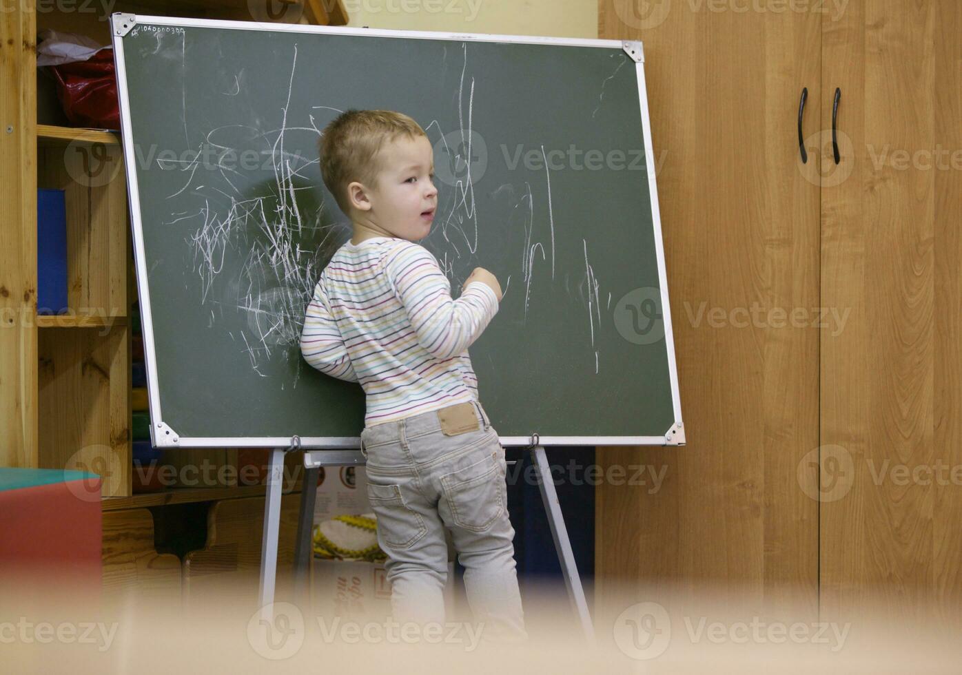 creatief weinig jongen tekening Aan een schoolbord foto