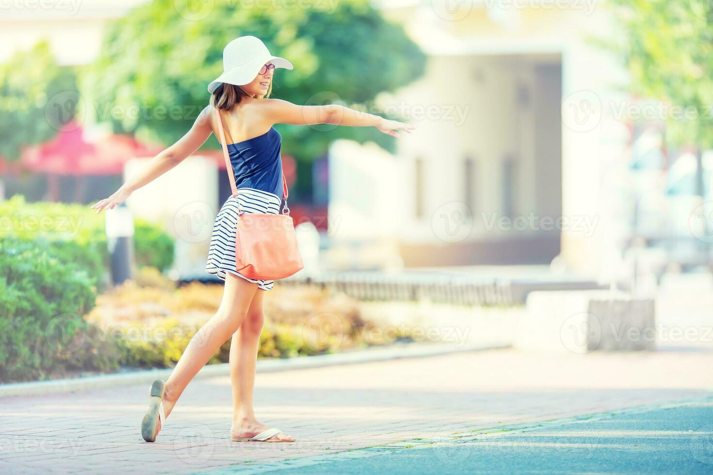 mooi schattig jong meisje dansen Aan de straat van geluk.schattig gelukkig meisje in zomer kleren dansen in de zon foto