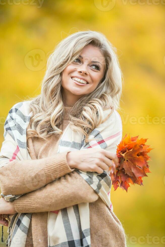 herfst portret van jong vrouw met boeket van esdoorn- bladeren foto