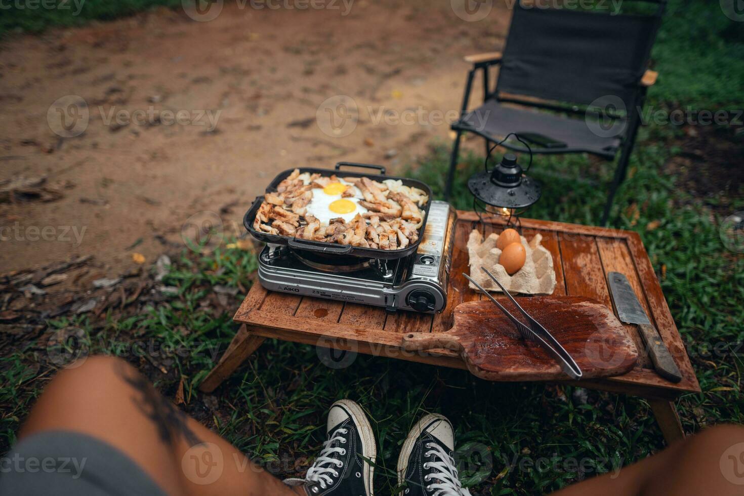 gebakken eieren en gegrild varkensvlees in een camping pan foto