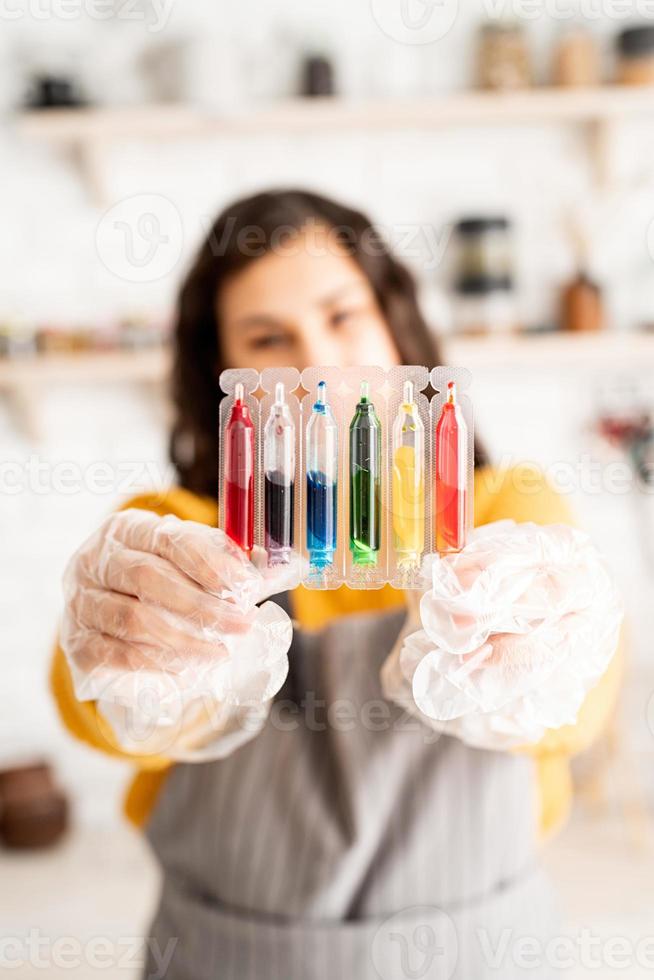 vrouw met buizen met kleurrijke vloeistoffen foto