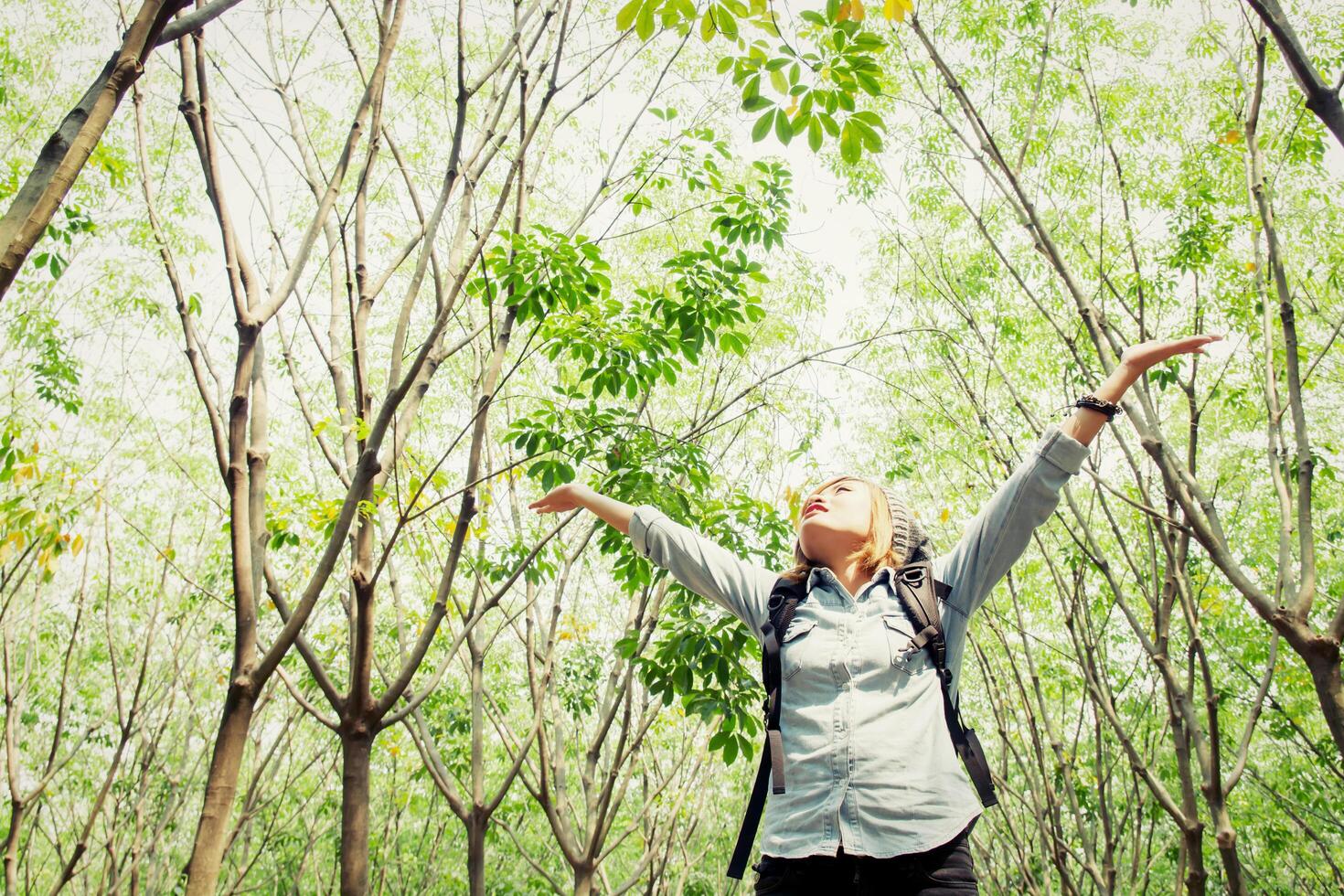 vrouw rugzak wandelen in bos stretch handen blij met frisse lucht foto