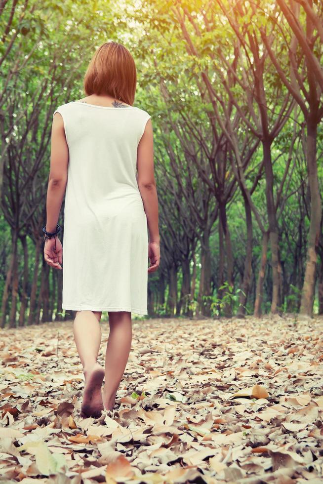 trieste vrouw die alleen in het bos loopt en zich verdrietig en eenzaam voelt foto