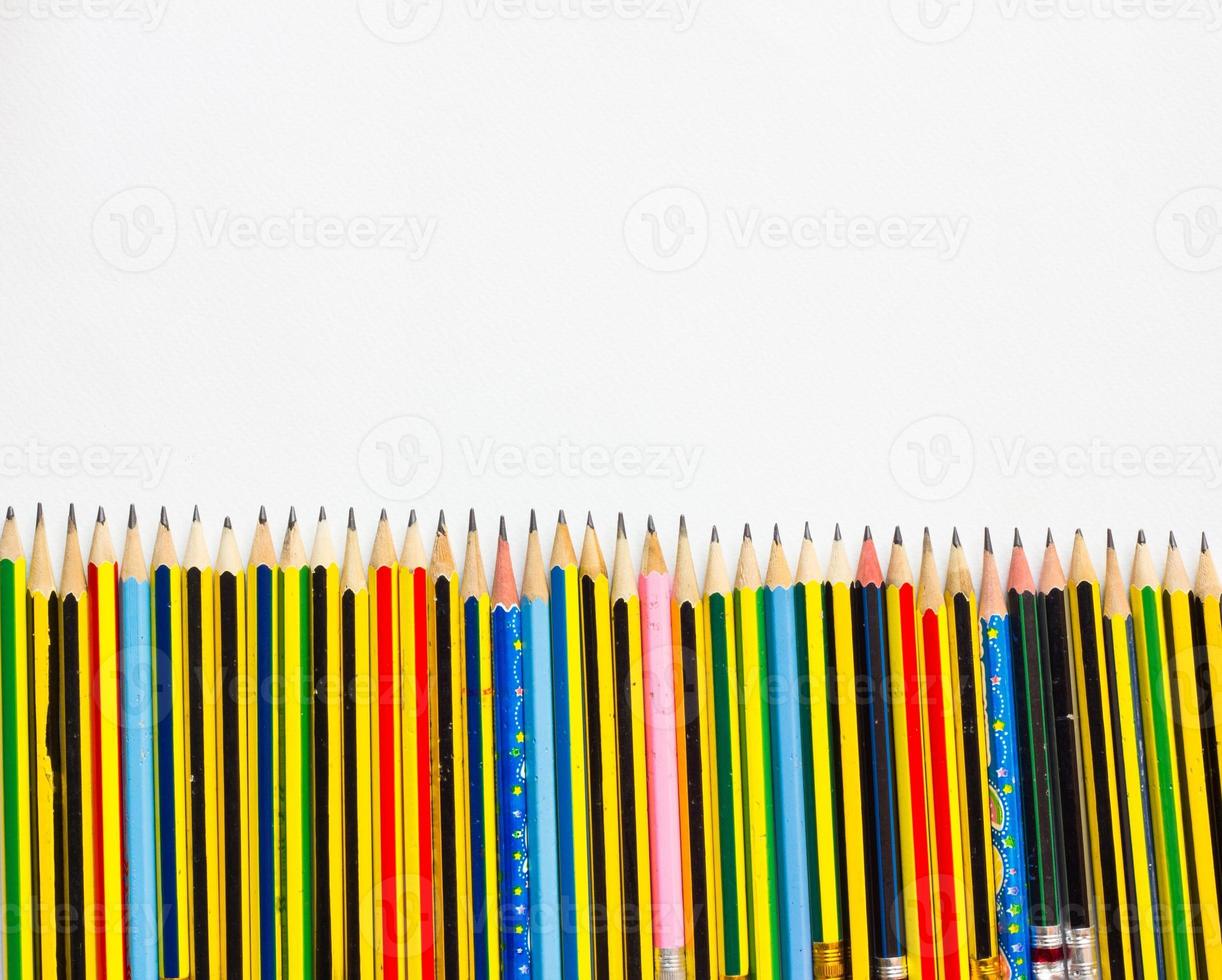 kleurrijke potloden op het witte papier, van bovenaf bekeken foto