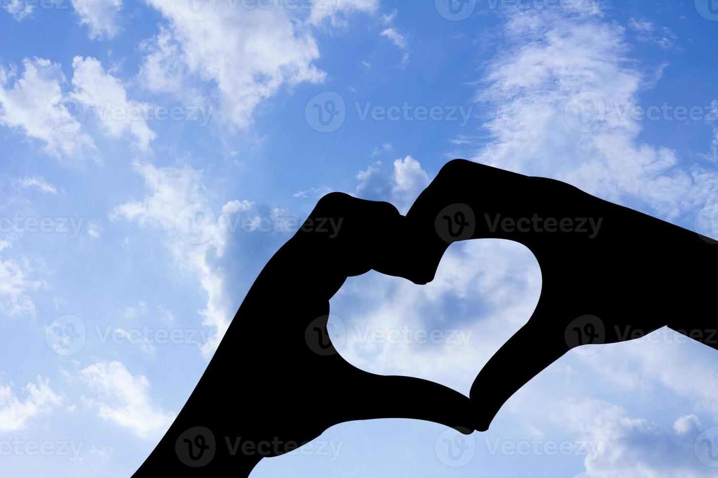 liefde vorm hand silhouet in blauwe lucht foto