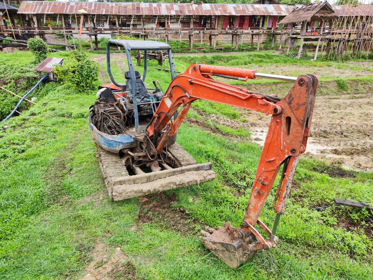 oude gebroken gele graafmachine in padieveld, thailand. foto