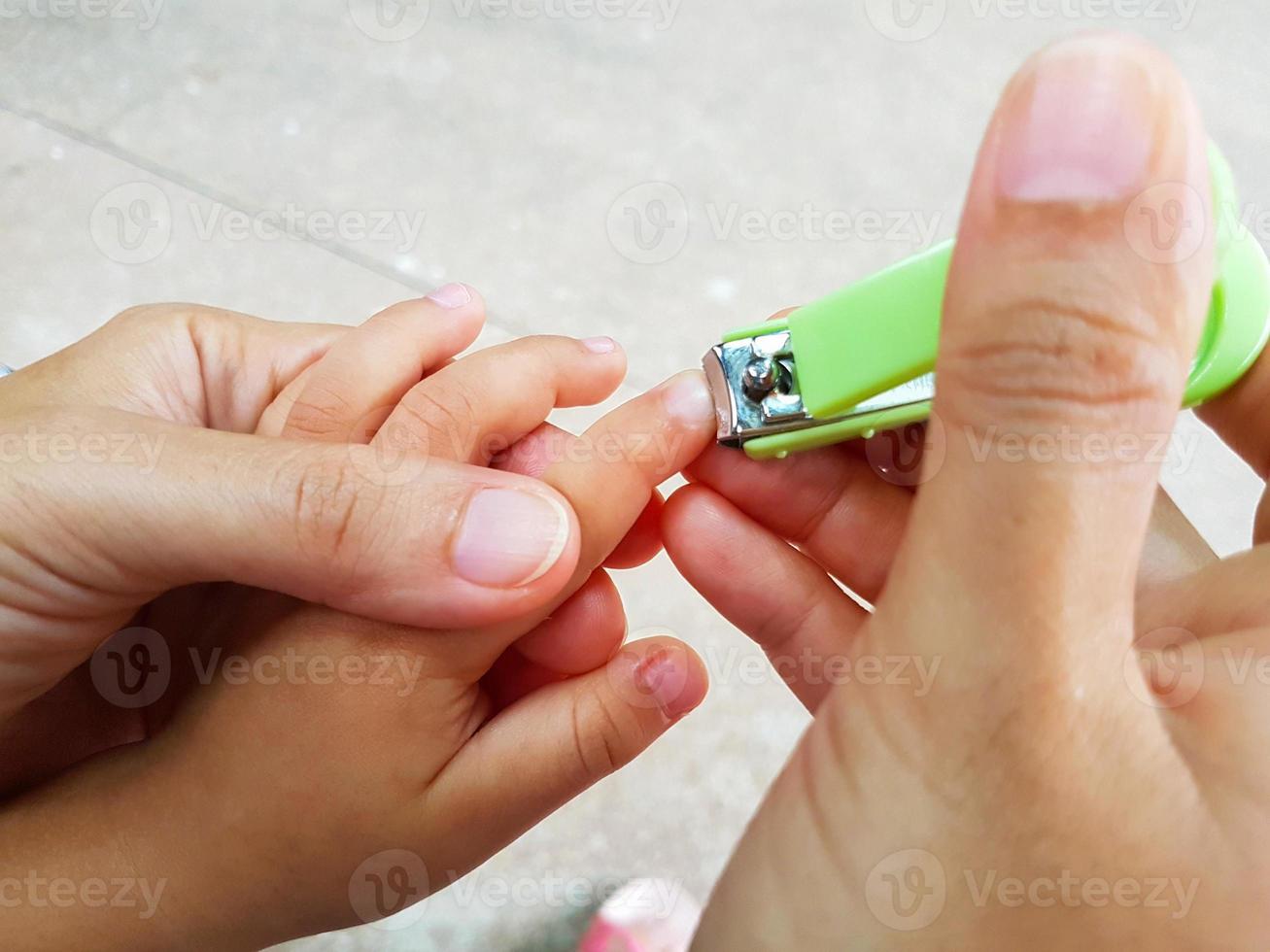 close-up moeder die vingernagels knipt voor haar baby foto