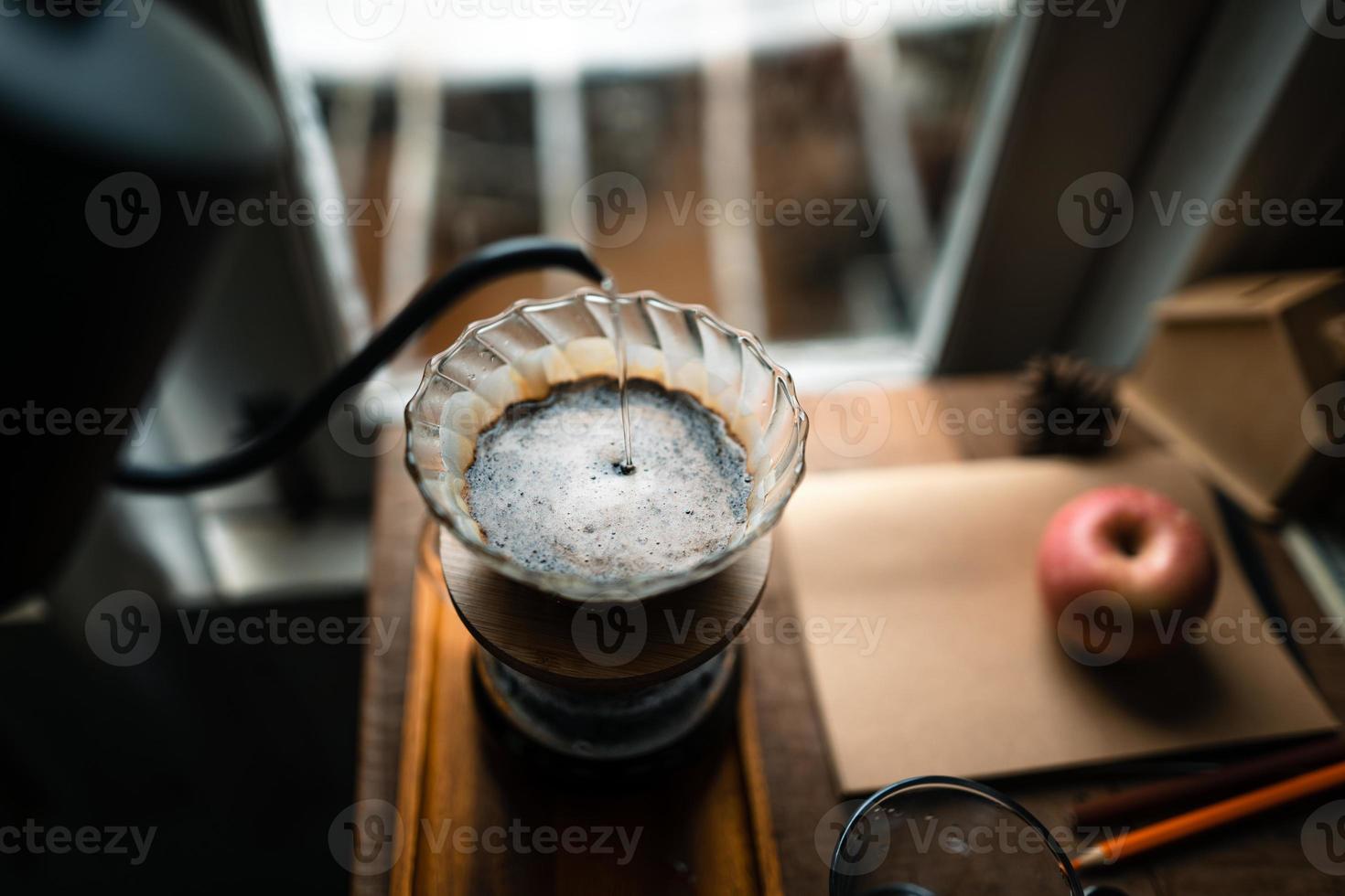 druppelkoffie in huis, een heet water over een druppelkoffie gieten foto