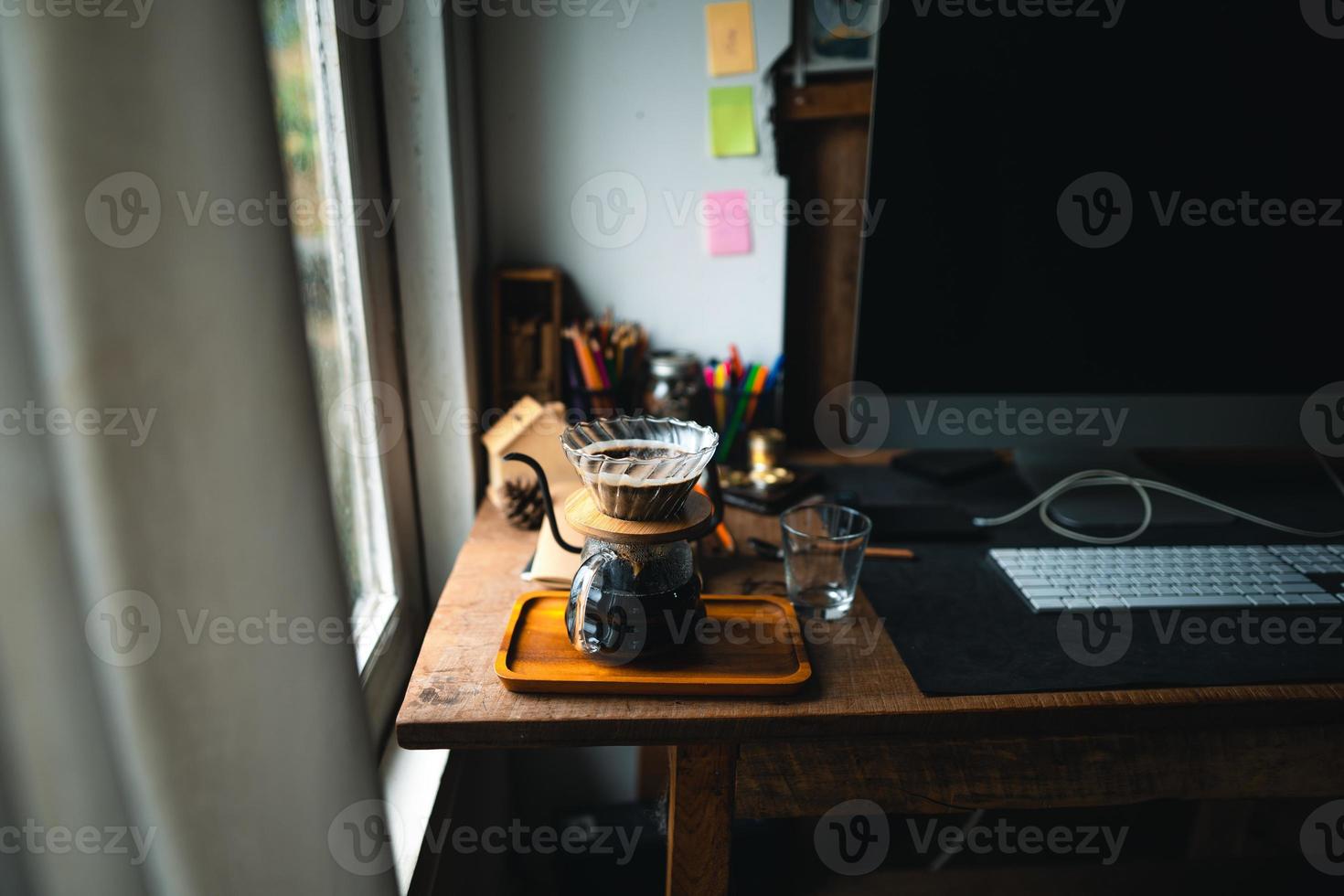 druppelkoffie in huis, een heet water over een druppelkoffie gieten foto