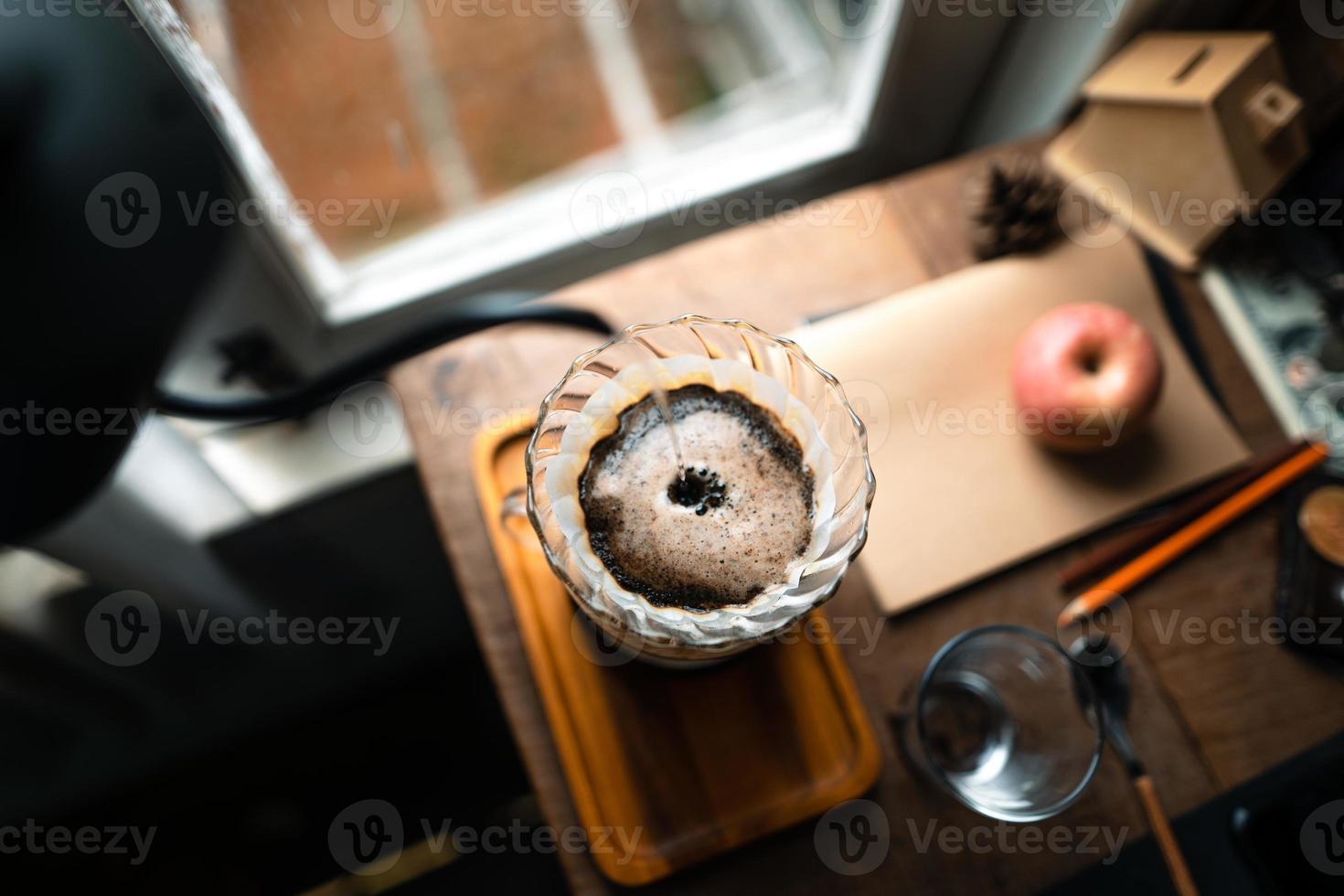 druppelkoffie in huis, een heet water over een druppelkoffie gieten foto