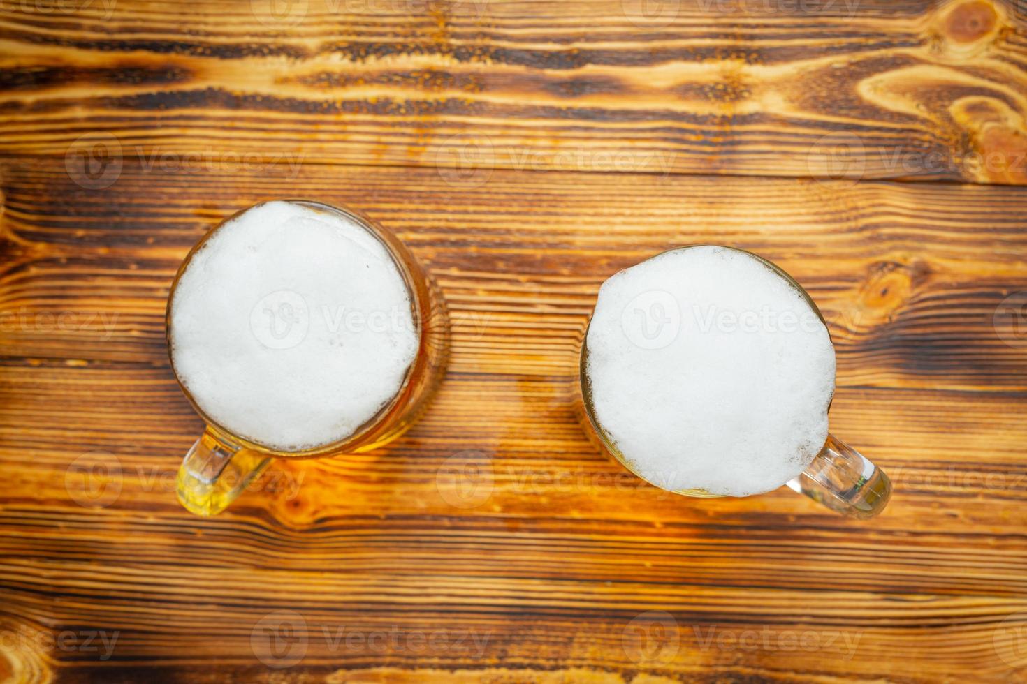 een glas bier wordt op de houten vloer geplaatst. foto