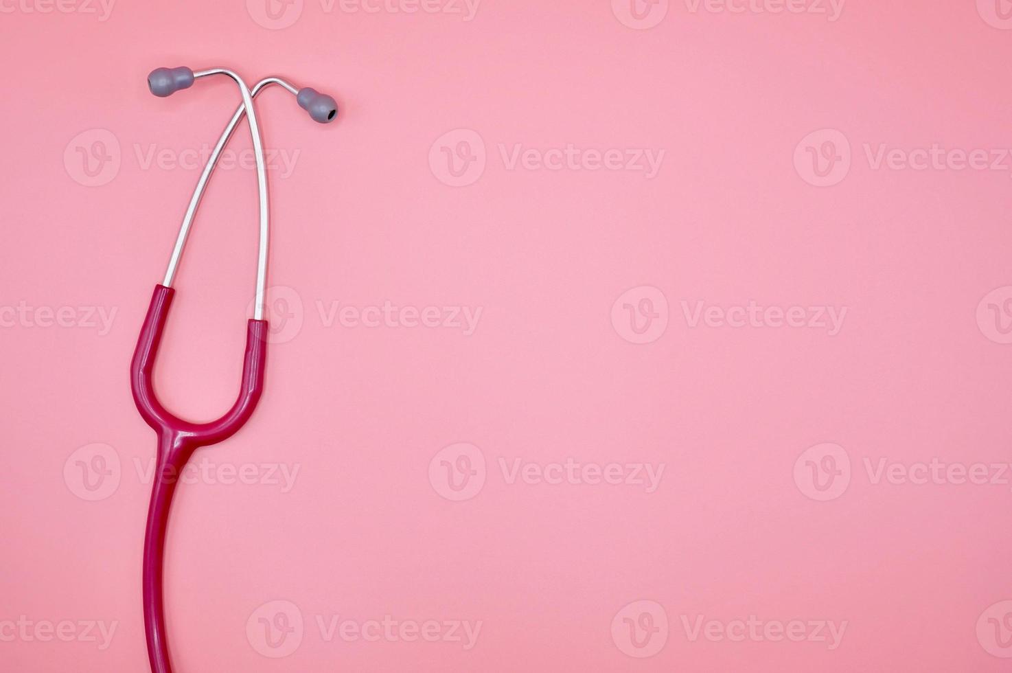 een roze stethoscoop op de roze achtergrond foto
